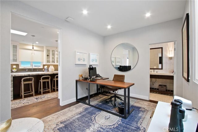 office area with recessed lighting, wood finished floors, baseboards, and a sink