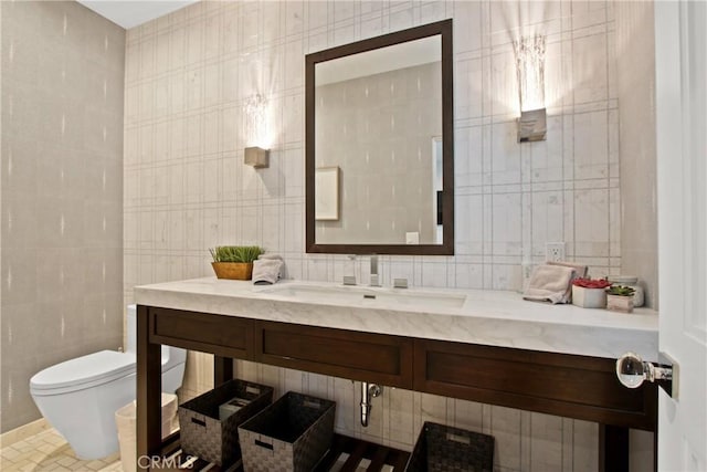 bathroom with vanity, tile walls, and toilet