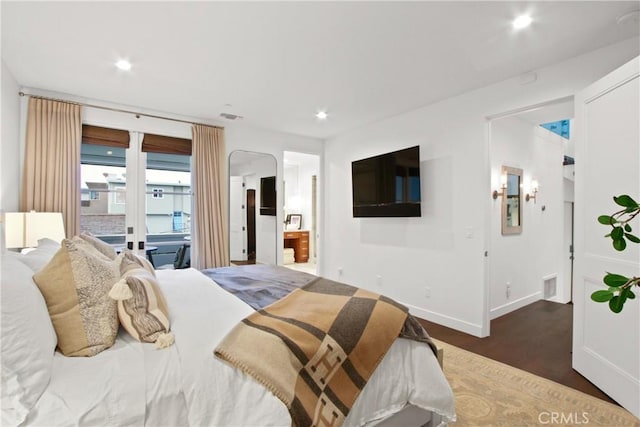 bedroom with visible vents, recessed lighting, wood finished floors, and arched walkways