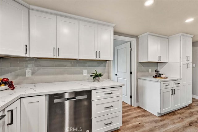 kitchen with light stone counters, stainless steel dishwasher, light wood-type flooring, and white cabinets