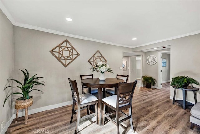 dining room with hardwood / wood-style flooring and ornamental molding