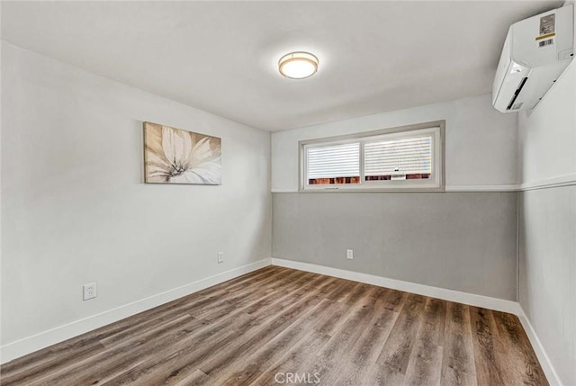 empty room with a wall mounted air conditioner and hardwood / wood-style floors