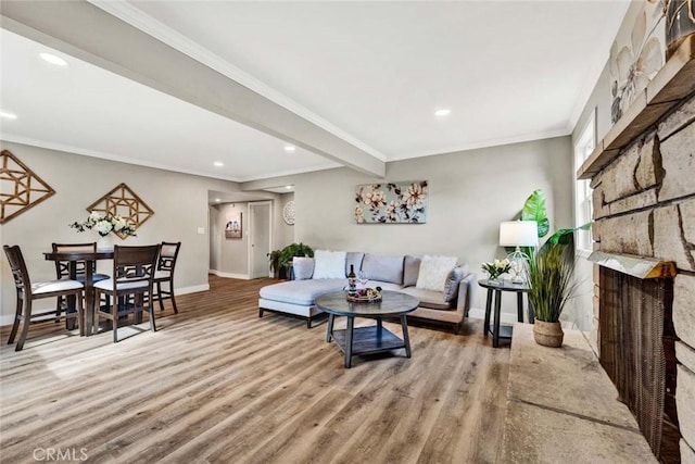 living room with hardwood / wood-style flooring, crown molding, a fireplace, and beamed ceiling