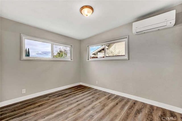 unfurnished room featuring hardwood / wood-style flooring, plenty of natural light, and a wall mounted air conditioner