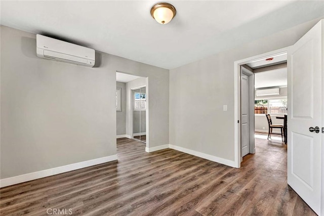 unfurnished room featuring a wall mounted air conditioner and dark hardwood / wood-style floors