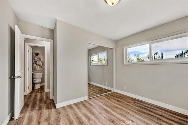 unfurnished bedroom with hardwood / wood-style flooring and a closet