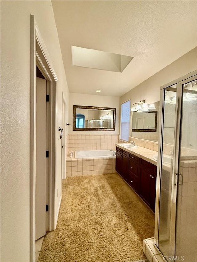 bathroom with vanity, shower with separate bathtub, and a textured ceiling