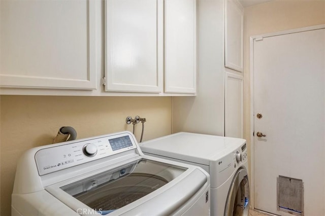 washroom with washer and clothes dryer and cabinets