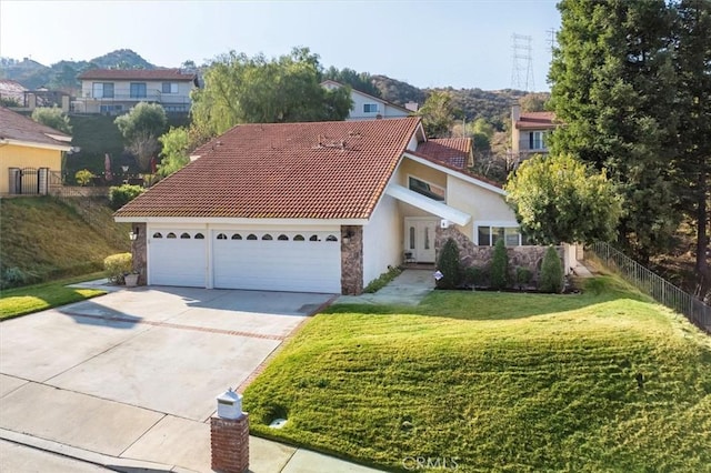 view of front of home featuring a garage, a mountain view, and a front lawn