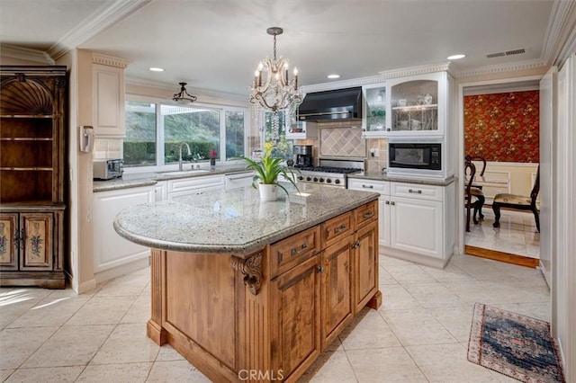 kitchen with a kitchen island, white cabinetry, black microwave, range, and wall chimney exhaust hood