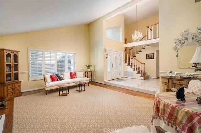 living room featuring hardwood / wood-style flooring, high vaulted ceiling, and a chandelier