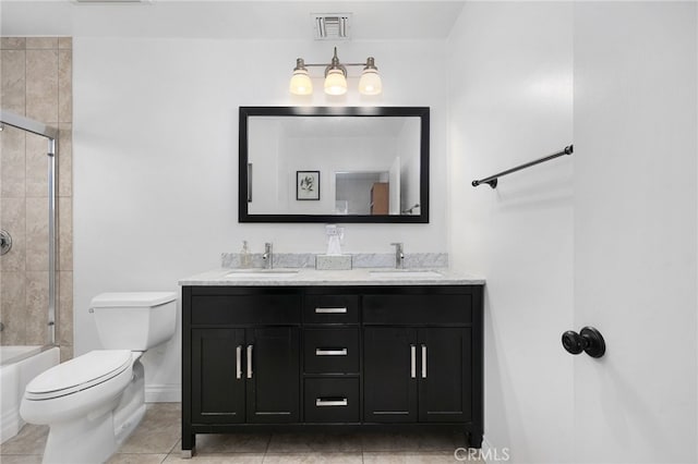 full bathroom featuring tile patterned flooring, vanity, bath / shower combo with glass door, and toilet