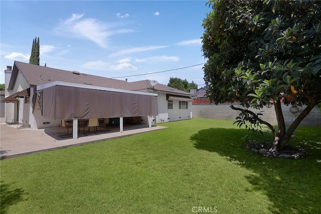 rear view of property featuring a yard and a patio area