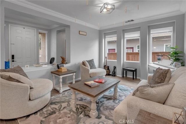 living room featuring baseboards, wood finished floors, visible vents, and crown molding