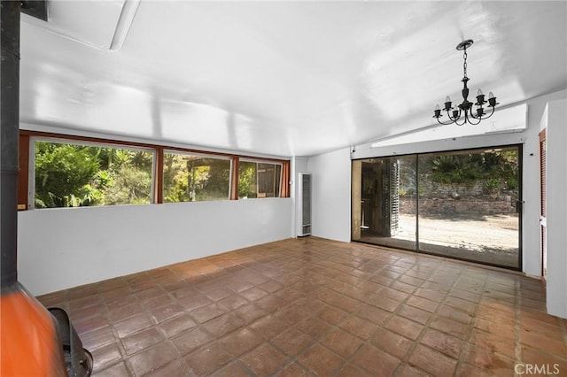 spare room with lofted ceiling, a wealth of natural light, and tile patterned floors