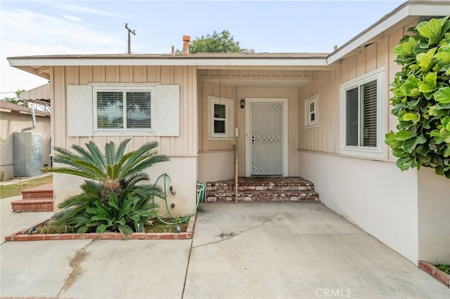 view of exterior entry with a patio area