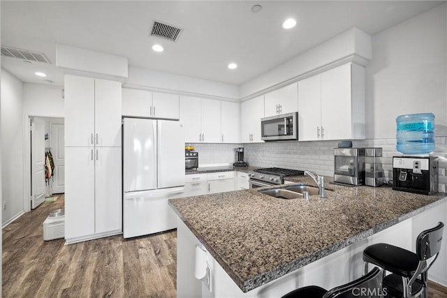 kitchen featuring stainless steel appliances, sink, white cabinets, and kitchen peninsula