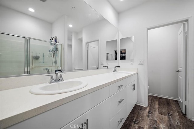 bathroom with vanity, hardwood / wood-style flooring, and a shower with door