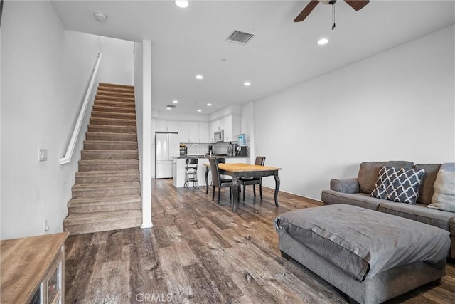 living room with dark wood-type flooring and ceiling fan