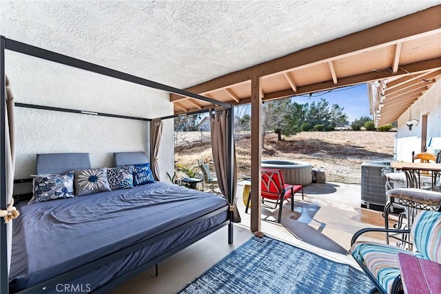 view of patio / terrace with a hot tub, an outdoor hangout area, and central AC