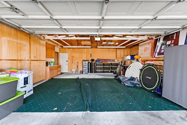 garage featuring a garage door opener and wood walls