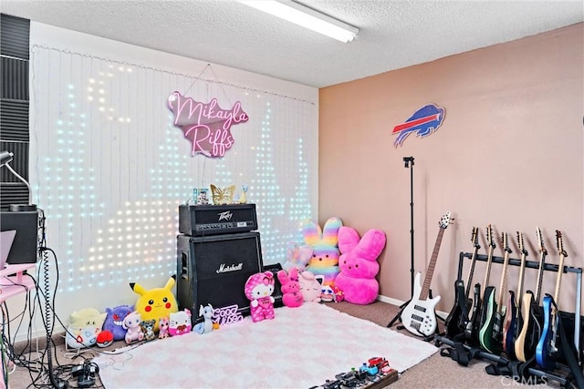 rec room with carpet floors and a textured ceiling