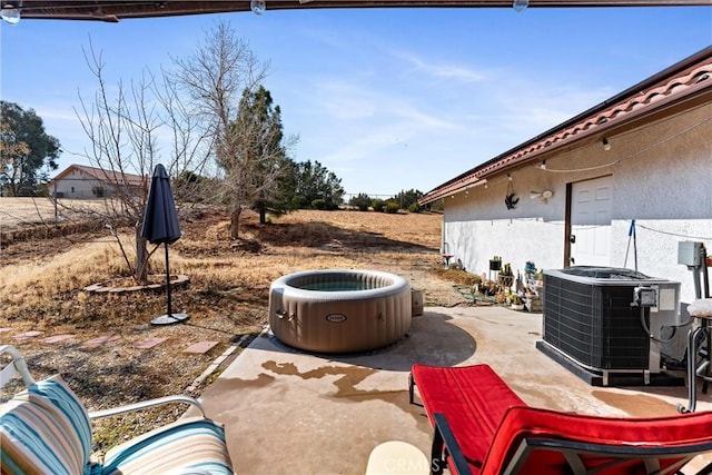 view of patio with a hot tub and central air condition unit