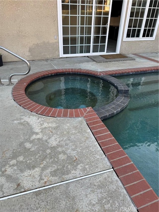 view of swimming pool featuring an in ground hot tub