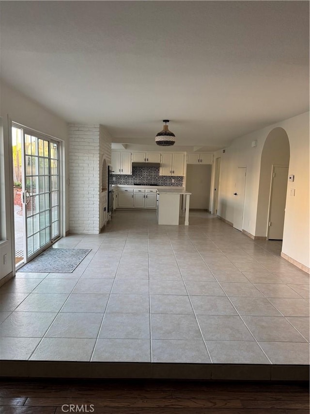 interior space with white cabinetry, light tile patterned flooring, and backsplash