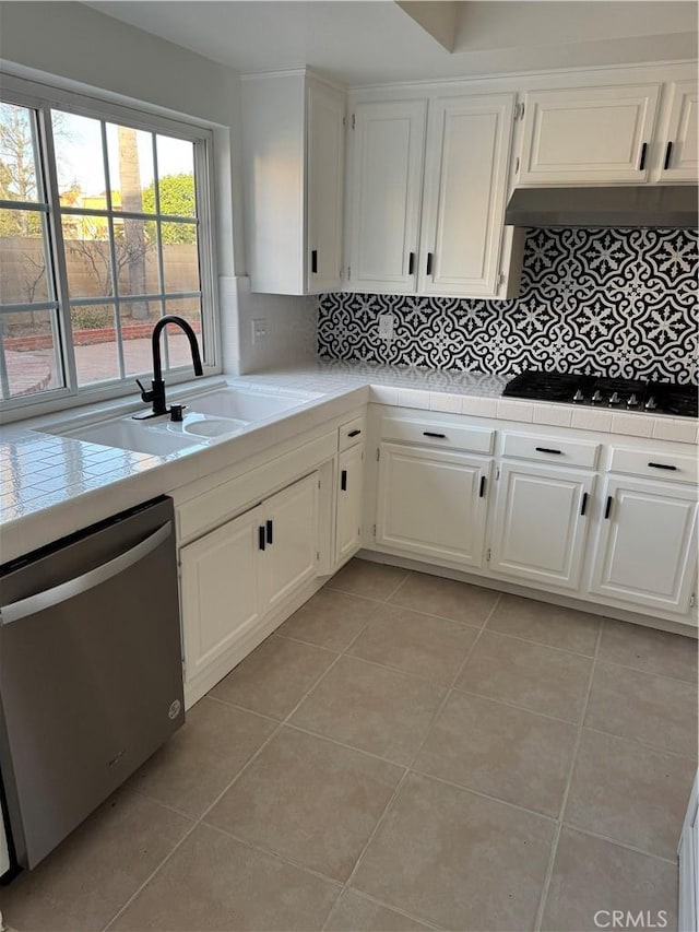 kitchen featuring sink, dishwasher, gas stovetop, white cabinets, and light tile patterned flooring