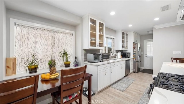 kitchen featuring white cabinetry, appliances with stainless steel finishes, sink, and light hardwood / wood-style floors