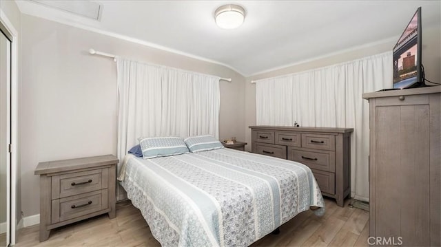 bedroom featuring vaulted ceiling and light hardwood / wood-style flooring