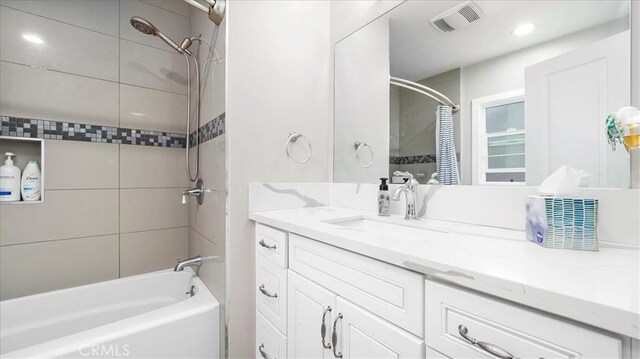 bathroom with vanity and tiled shower / bath combo