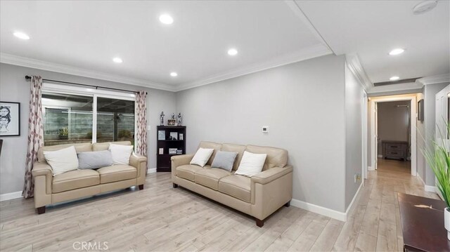 living room featuring crown molding and light wood-type flooring