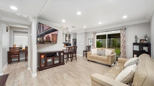 living room featuring crown molding and light hardwood / wood-style flooring