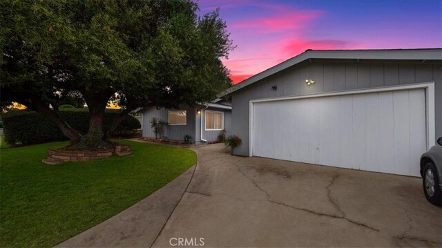 ranch-style home with a garage and a yard