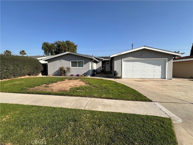 single story home featuring a front lawn, an attached garage, and driveway