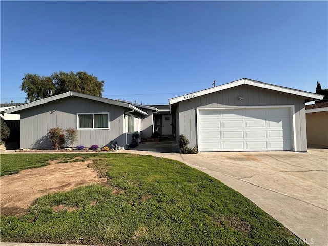 view of front of home featuring concrete driveway, an attached garage, and a front yard