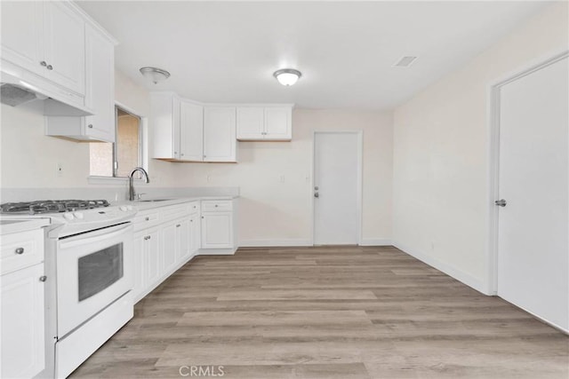 kitchen featuring white cabinetry, sink, white gas stove, and light hardwood / wood-style floors