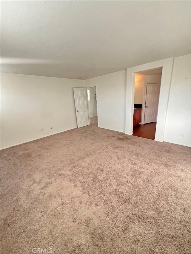 spare room featuring dark colored carpet