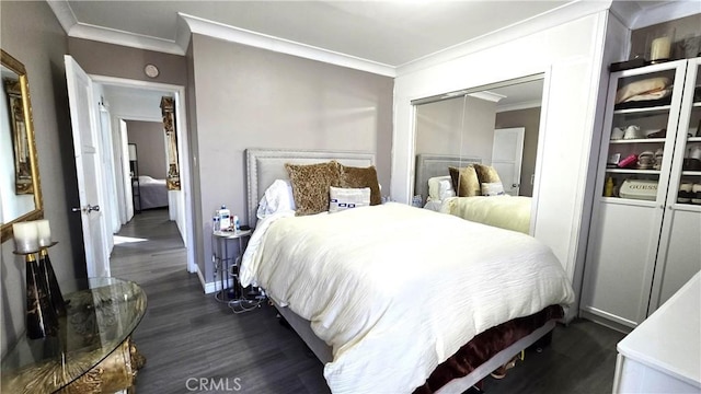 bedroom featuring dark wood-type flooring, crown molding, and a closet