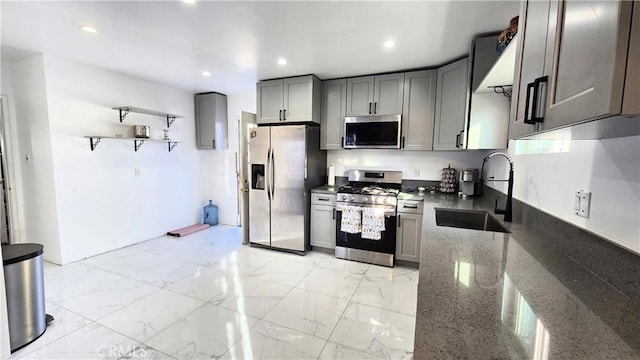 kitchen with gray cabinetry, sink, dark stone countertops, and appliances with stainless steel finishes