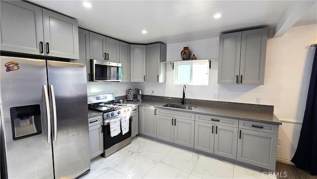 kitchen with appliances with stainless steel finishes, gray cabinets, and sink