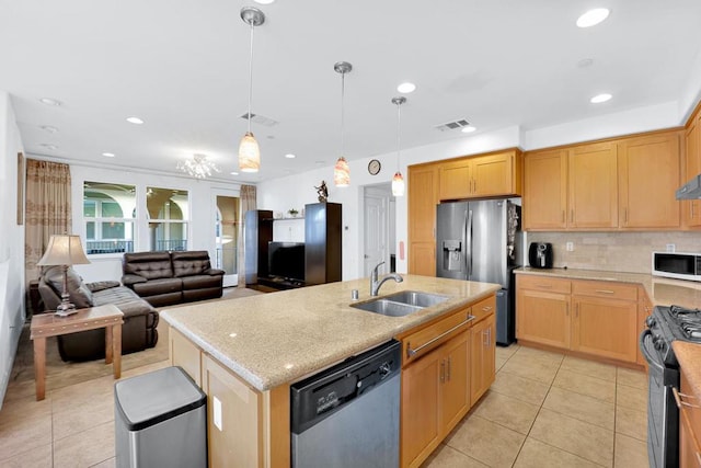 kitchen with sink, appliances with stainless steel finishes, hanging light fixtures, a center island with sink, and light tile patterned flooring