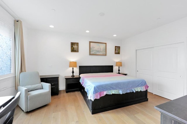 bedroom with light wood-type flooring and a closet