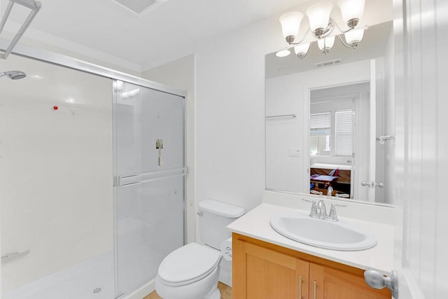 bathroom with vanity, toilet, and a shower with door