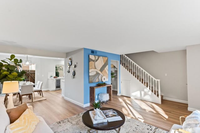 living room with beverage cooler and light hardwood / wood-style flooring