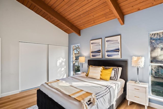 bedroom with wood ceiling, light hardwood / wood-style floors, lofted ceiling with beams, and a closet