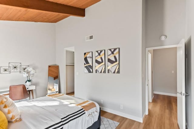 bedroom featuring wood ceiling, high vaulted ceiling, beam ceiling, and light hardwood / wood-style floors