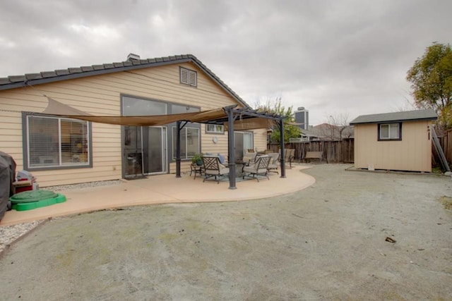 rear view of house featuring a storage shed, a pergola, and a patio